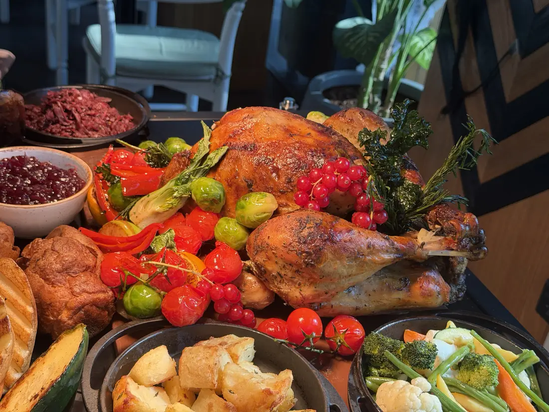 A roasted Christmas turkey with vegetables and cranberry sauce