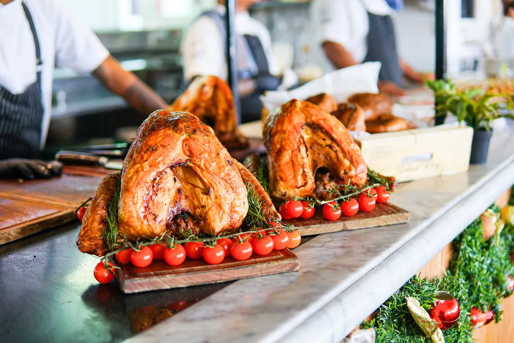 Roast Christmas turkeys on wooden boards with tomatoes on the vine